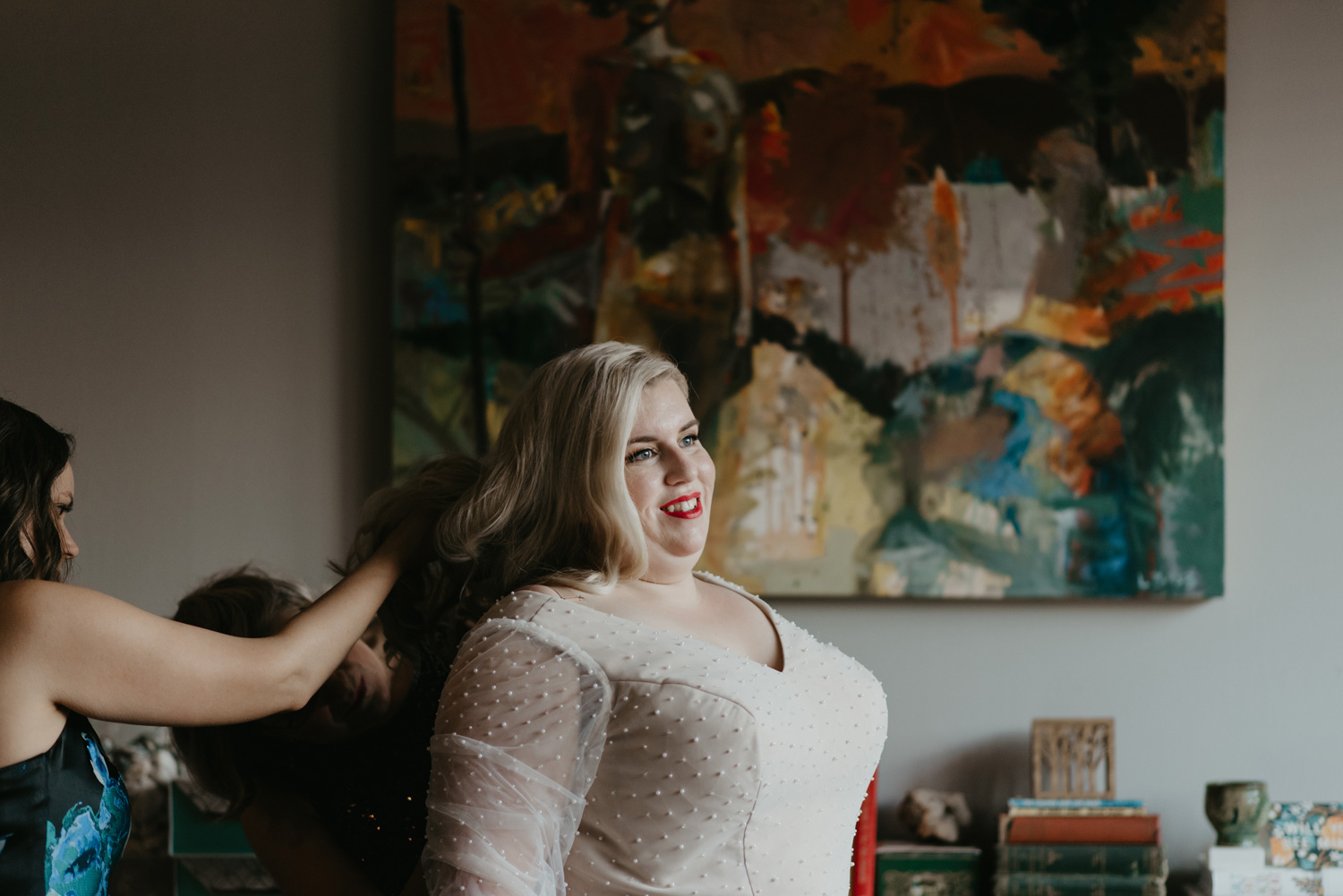 Bride getting ready in front of abstract painting