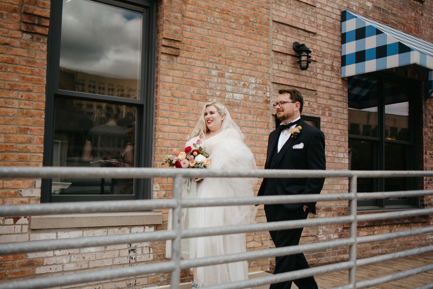 Bride and groom walking outside of venue together