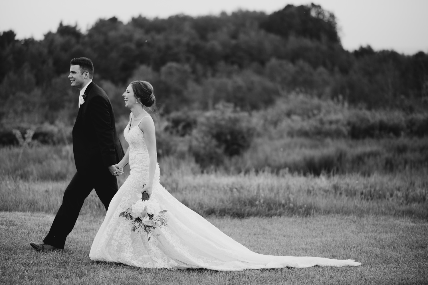 Bride and Groom walking together in a field