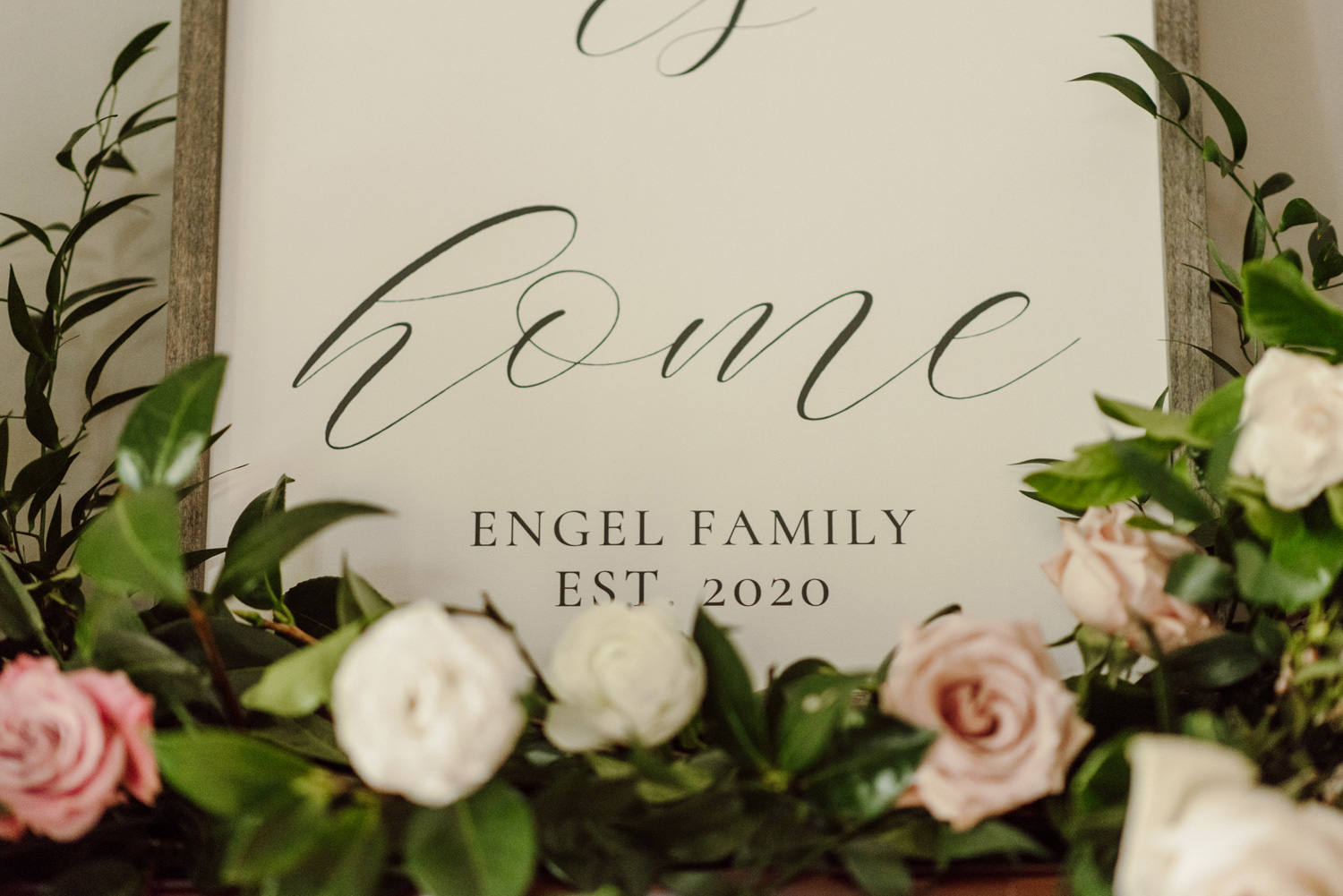 white and pink roses in front of personalized sign wedding