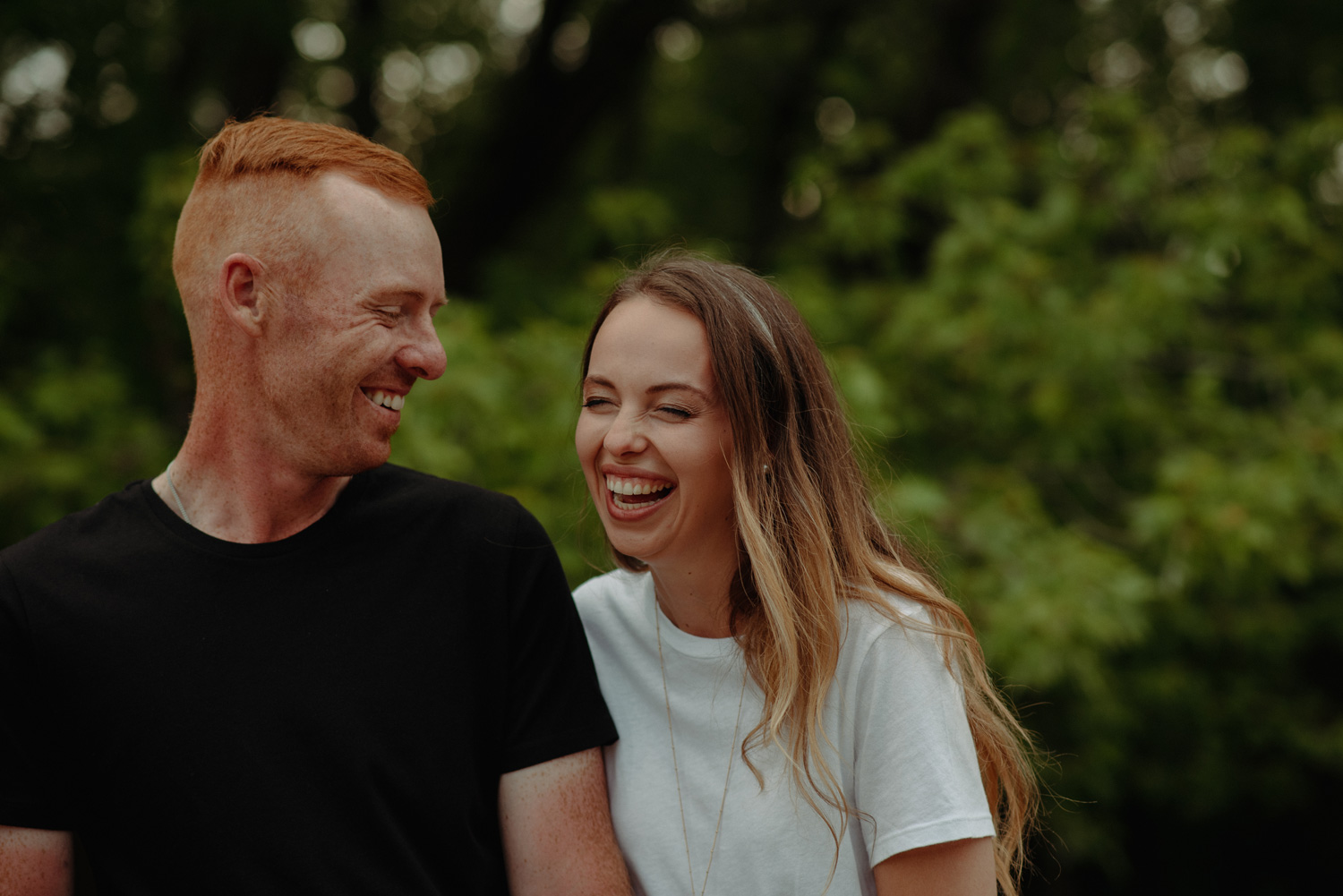 Couple holding hands and laughing minnehaha river engagement photos