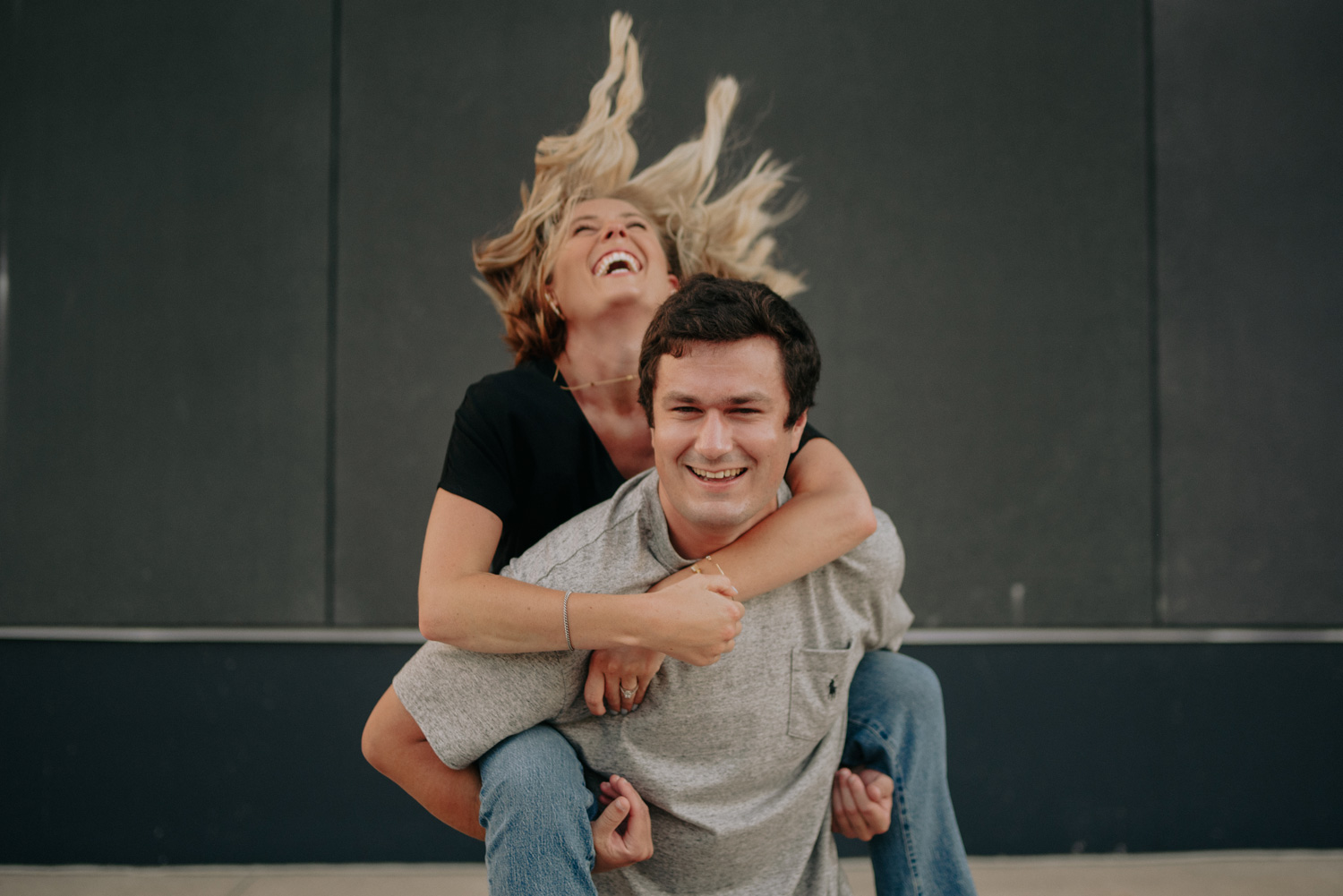 engaged couple laughing piggy back ride minneapolis