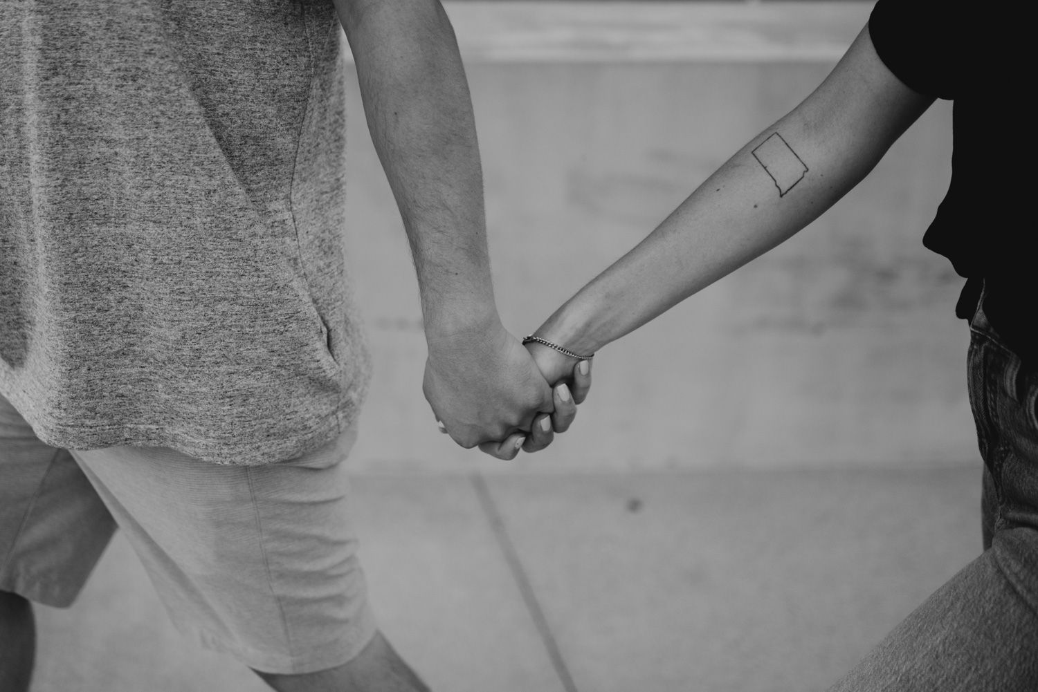 black and white couple holding hands with tattoo