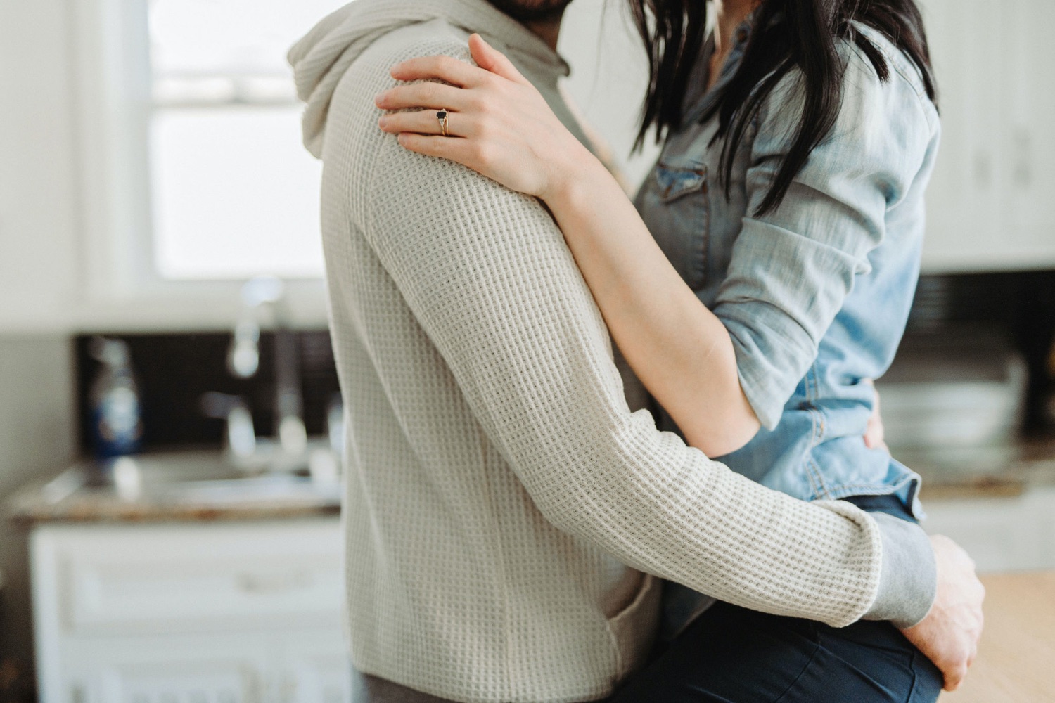 couple cuddling in the kitchen intimate in home session