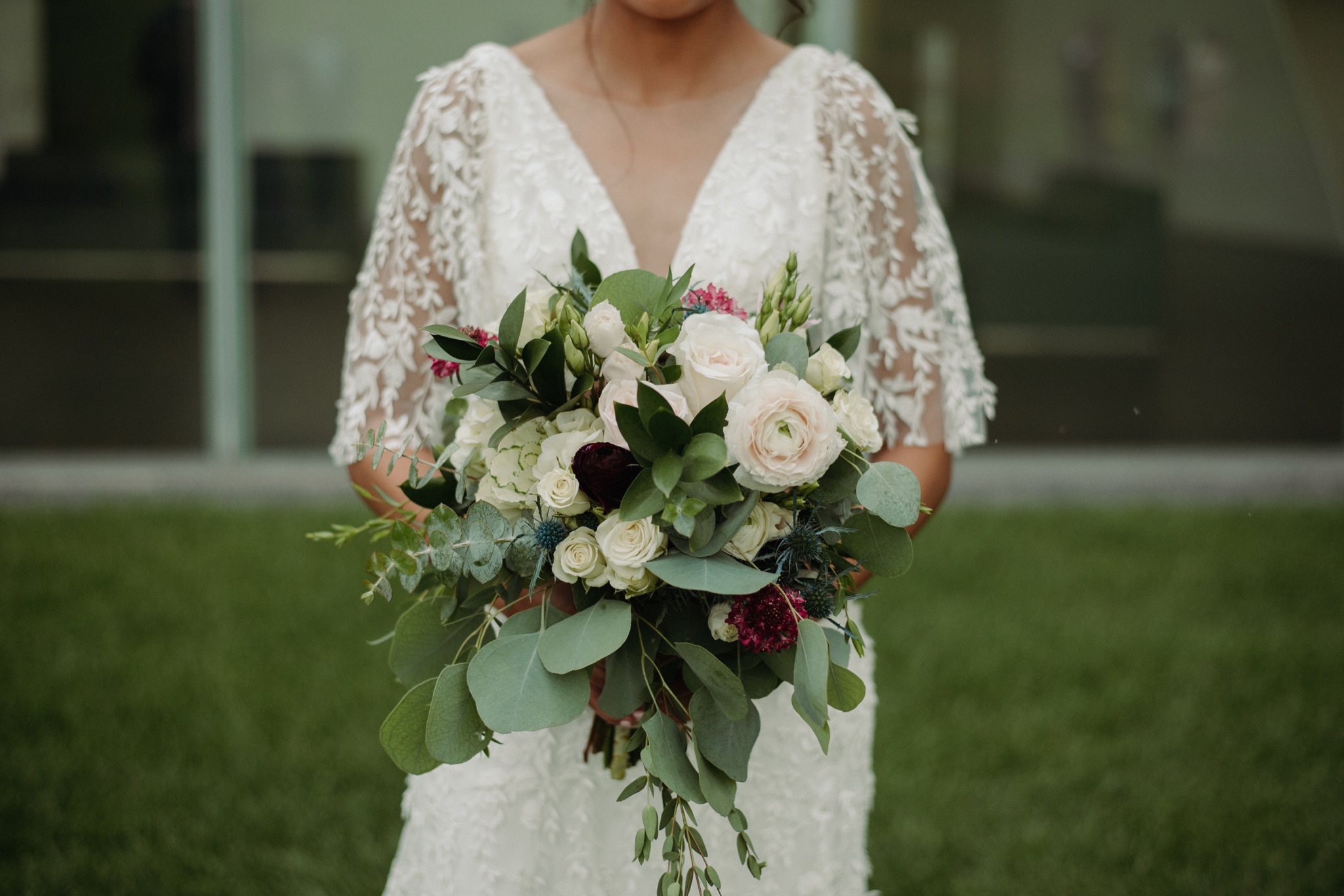 Bride holding flowers in front of her chest walker art center wedding