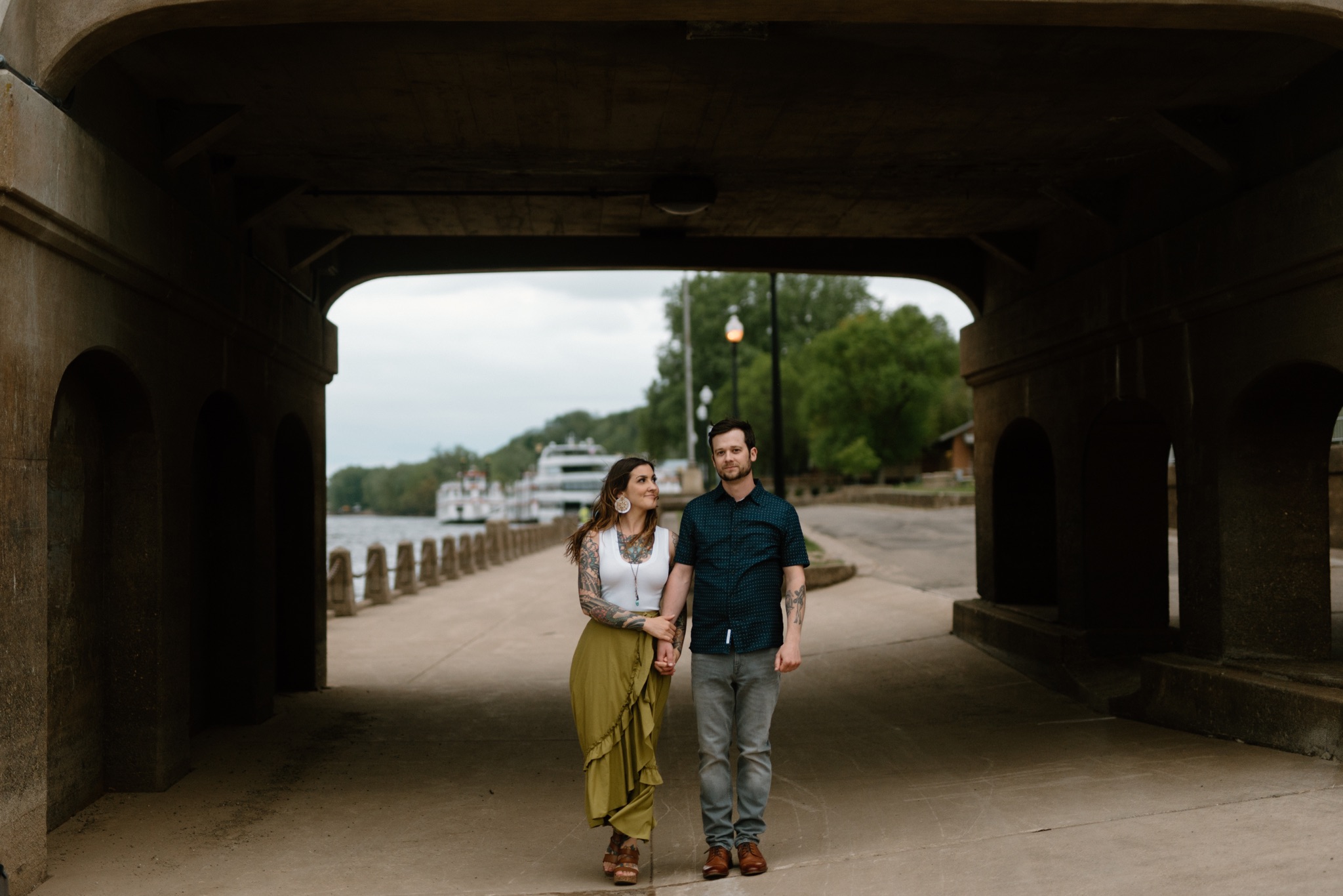 man and woman walking under a bridge