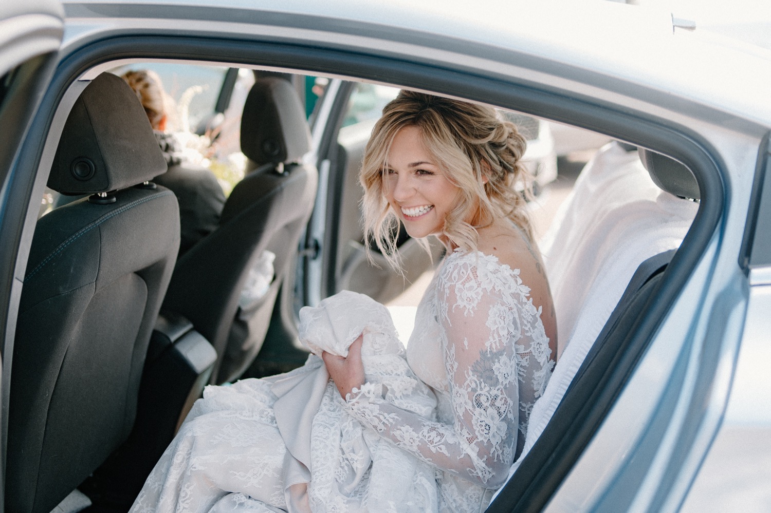 bride sitting in back seat of a car