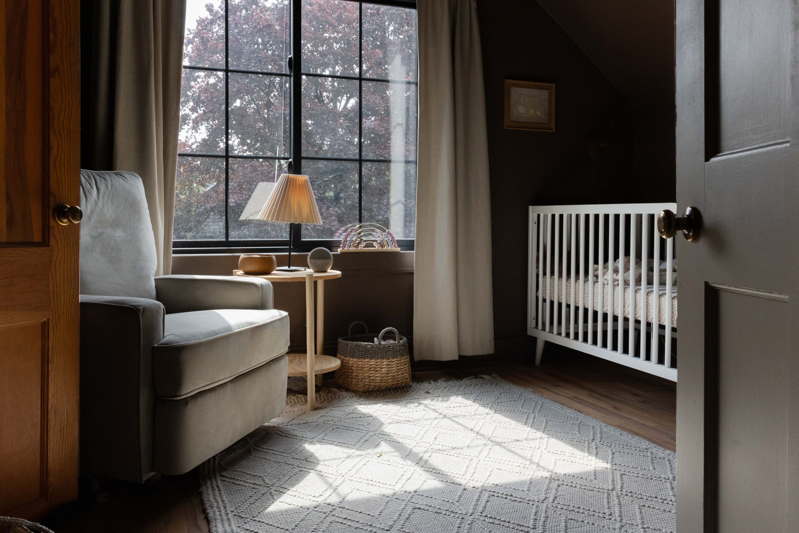 Moody nursery with direct sunlight streaming in from large picture window